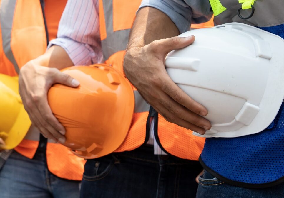 Three_People_Holding_HardHats_on_hips